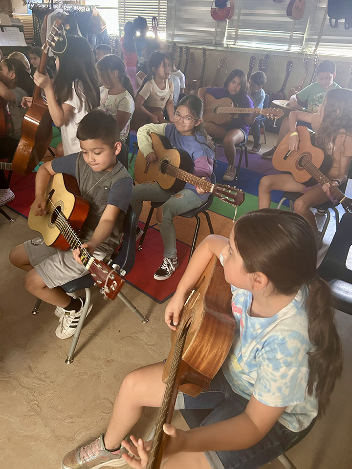 Students play guitar in music class