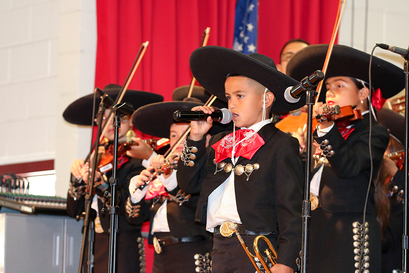 Students sing and play violin in mariachi costumes