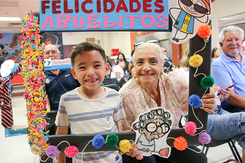A little boy and his grandma smile in a Felicidades Abuelitos photo frame