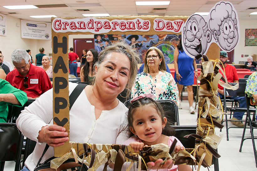 A woman and her granddaughter pose in a Grandparents Day photo frame