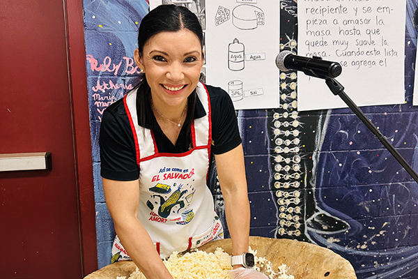 A woman mixes a bowl of masa