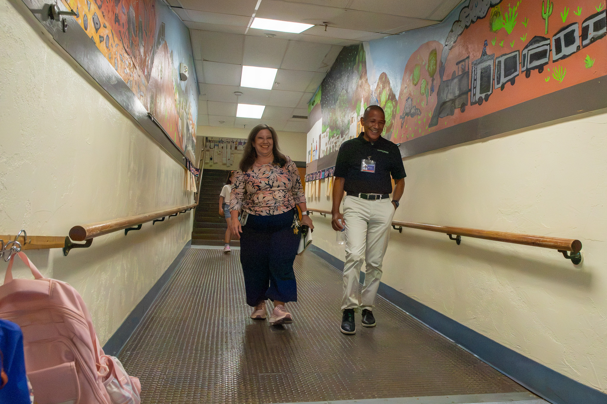Davis' principal and Dr. Trujillo walk down a school hallway