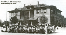 A black and white photo of Davis when it first opened. Students and faculty are gathered on the lawn.